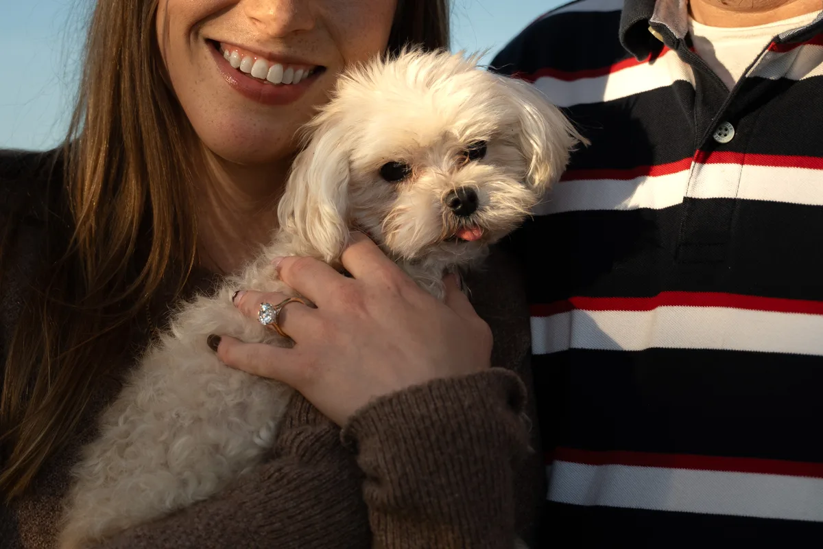Close detail of her smile, the new engagement ring and their small white dog, Mahoney State Park, Nebraska